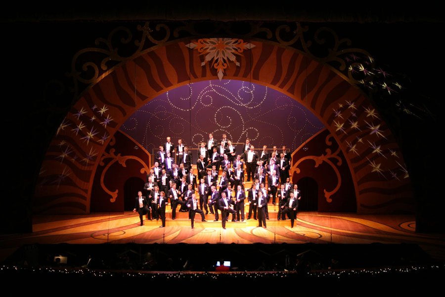 Tuxedos under ornate arch with elegant, sophisticated scenic design